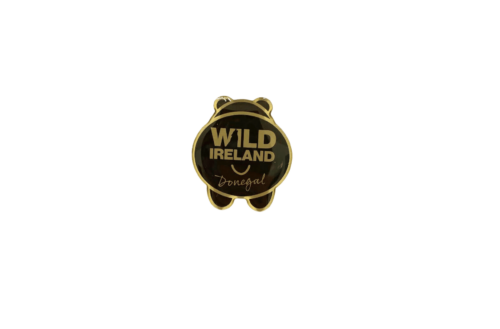 Wild Ireland - The Bear Bum Pin Badge is a metal pin featuring an animal shape with rounded ears and legs, displaying Wild Ireland and Donegal on a black circular background.
