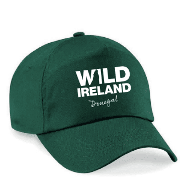 Wild Ireland - A bright pink baseball cap with Wild Ireland in bold white letters on the front and Donegal in cursive below, featuring an adjustable strap at the back.