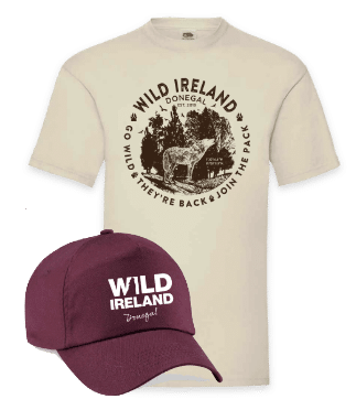 Wild Ireland - A beige T-shirt features a Wild Ireland design with a wolf and forest. Text reads Donegal, Go Wild, Theyre Back, and Join the Pack. Accompanying the shirt is a maroon cap with Wild Ireland Donegal written in white.